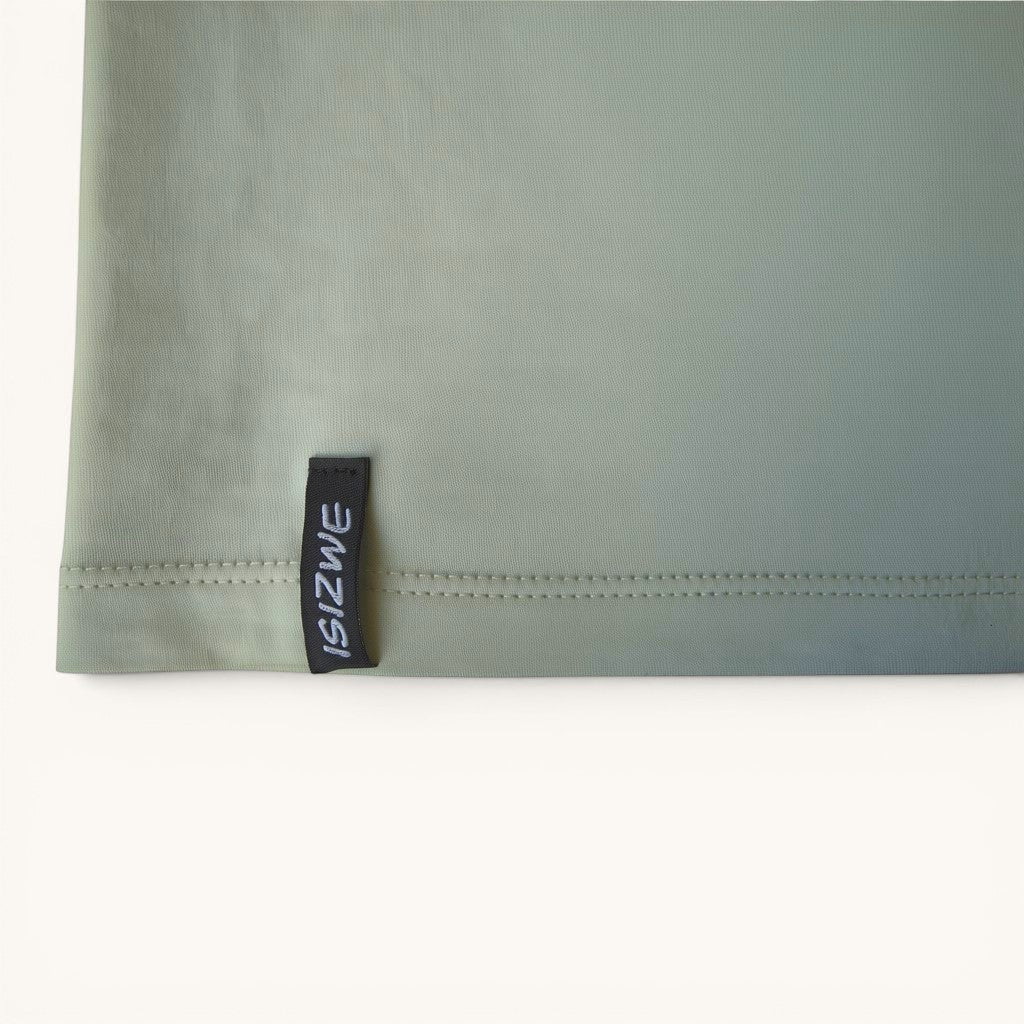 Camiseta ISIZWE de algodón verde salvia con etiqueta lateral distintiva. Estampado gráfico en la espalda.