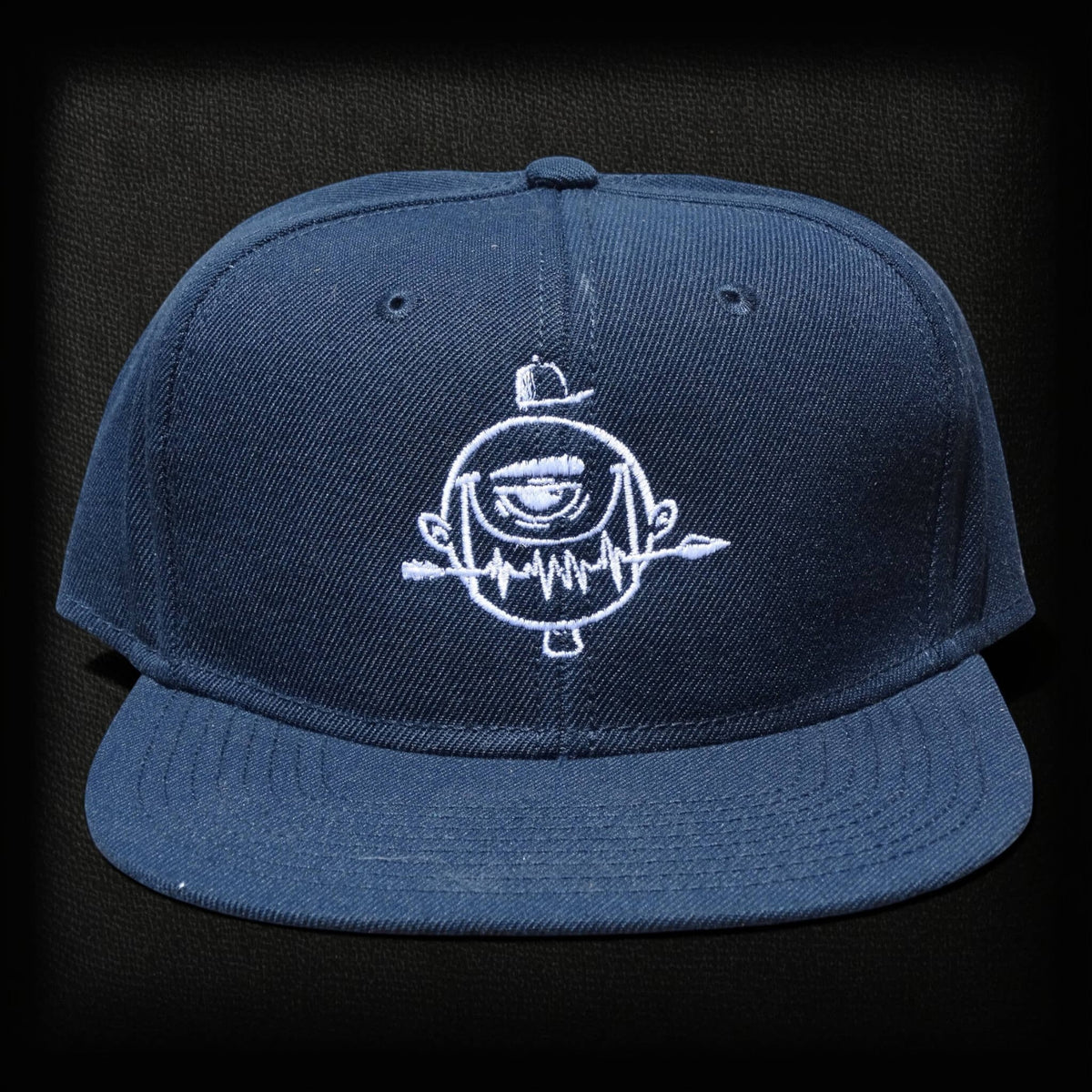 Gorra ISIZWE azul marino de algodón con bordado frontal de personaje y cierre ajustable. Estilo snapback.