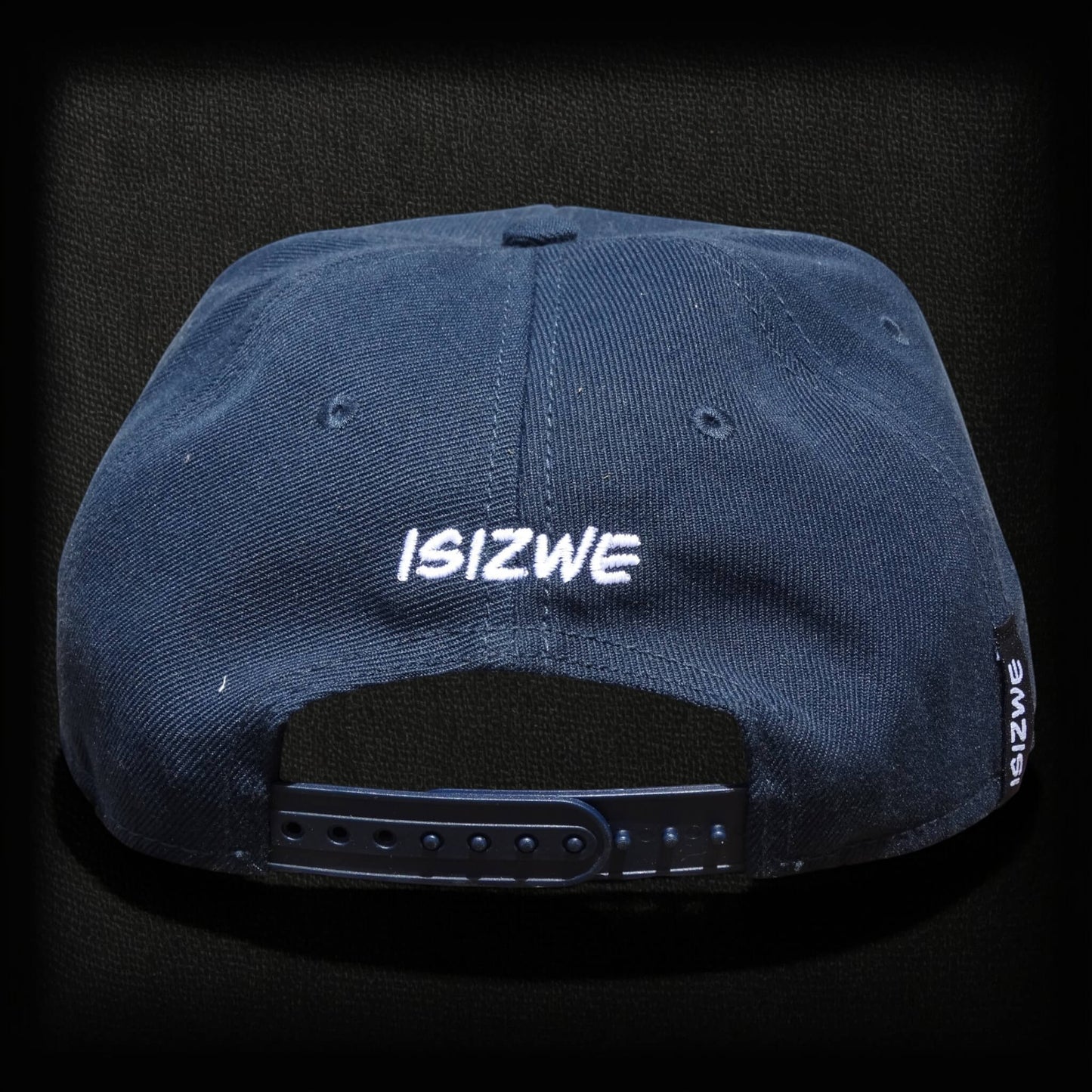 Gorra azul marino de algodón ISIZWE con cierre a presión ajustable y bordado de la marca en la parte trasera.
