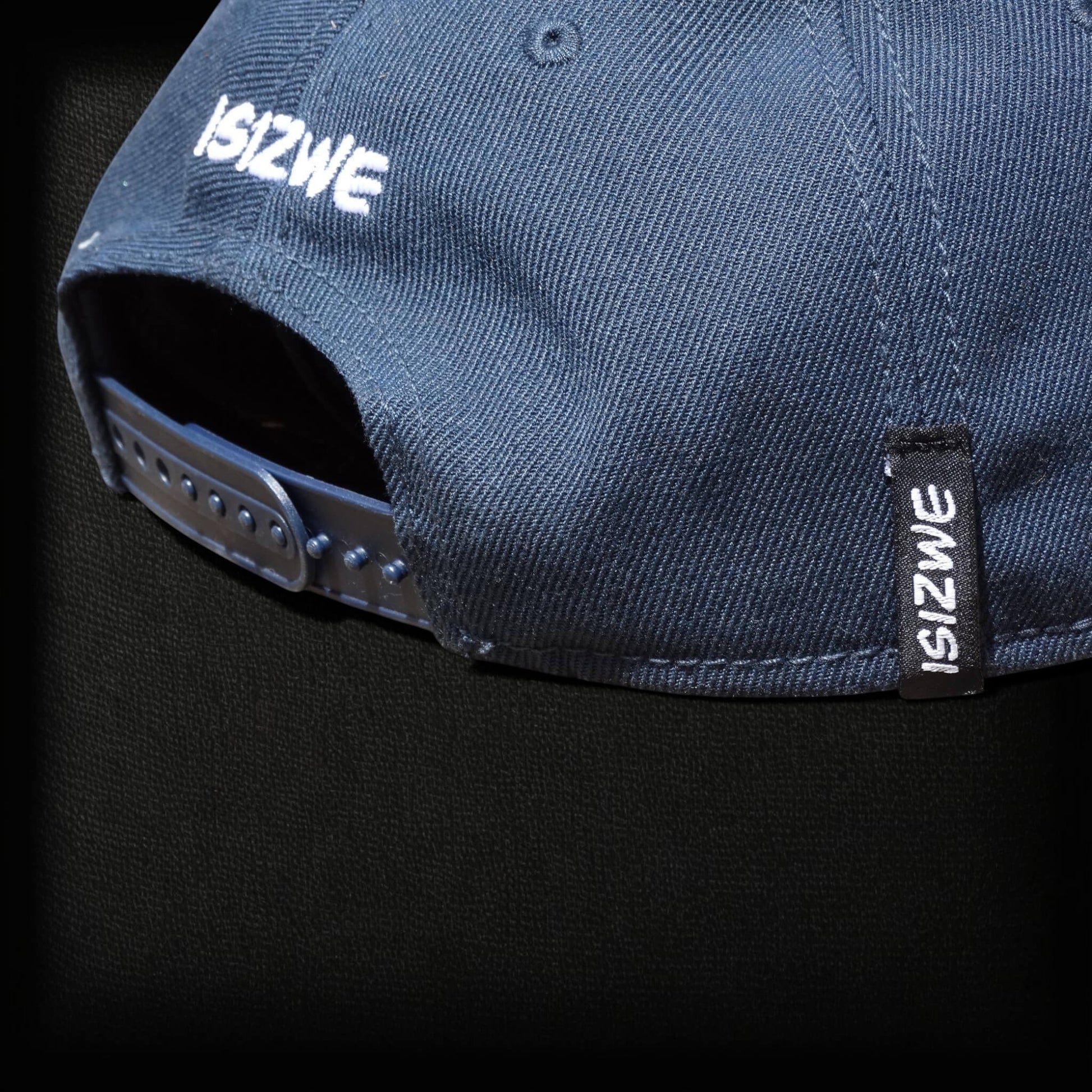 Gorra ISIZWE azul marino de algodón con cierre ajustable y etiqueta de marca en la parte trasera.